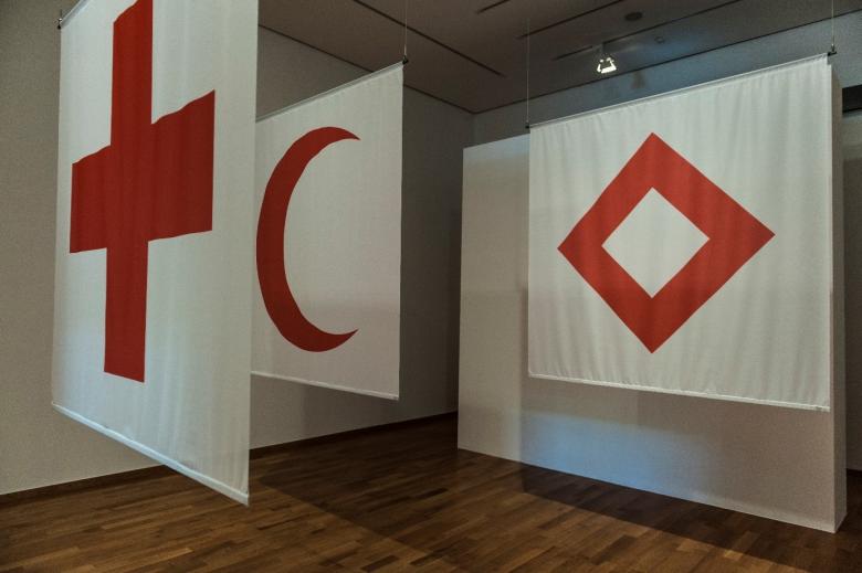 The red cross, red crescent and red crystal emblems provide protection for medical services in armed conflicts and are used by national Red Cross and Red Crescent Societies to identify themselves. As a compliment to Switzerland, the heraldic emblem of the red cross on a white ground is formed by reversing the Federal colors of the Swiss flag. © ICRC archives (ARR)