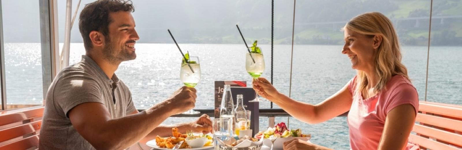 Una coppia assapora un pasto a bordo di un battello a vapore, Lago dei Quattro Cantoni, Svizzera centrale © Swiss Travel System SA, 2019, fotografo: Daniel Ammann