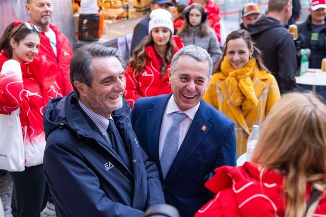Federal Councillor Ignazio Cassis interacting with guests during a public event surrounded by spectators and event staff.