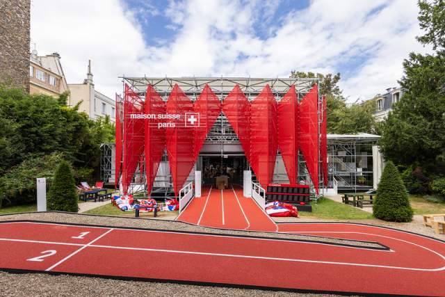 Vue extérieure de la Maison Suisse avec sa façade rouge dans les jardins de l'Ambassade de Suisse à Paris.