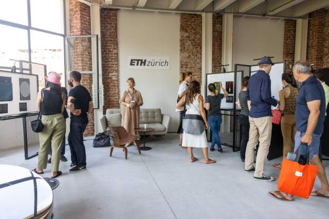 Visitors exploring an ETH Zürich exhibition in a bright, modern space at the House of Switzerland Milano.