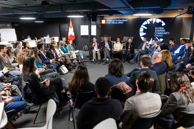 Room of people sitting in a circle at the Global Shapers Community session at the WEF 2025 in Davos