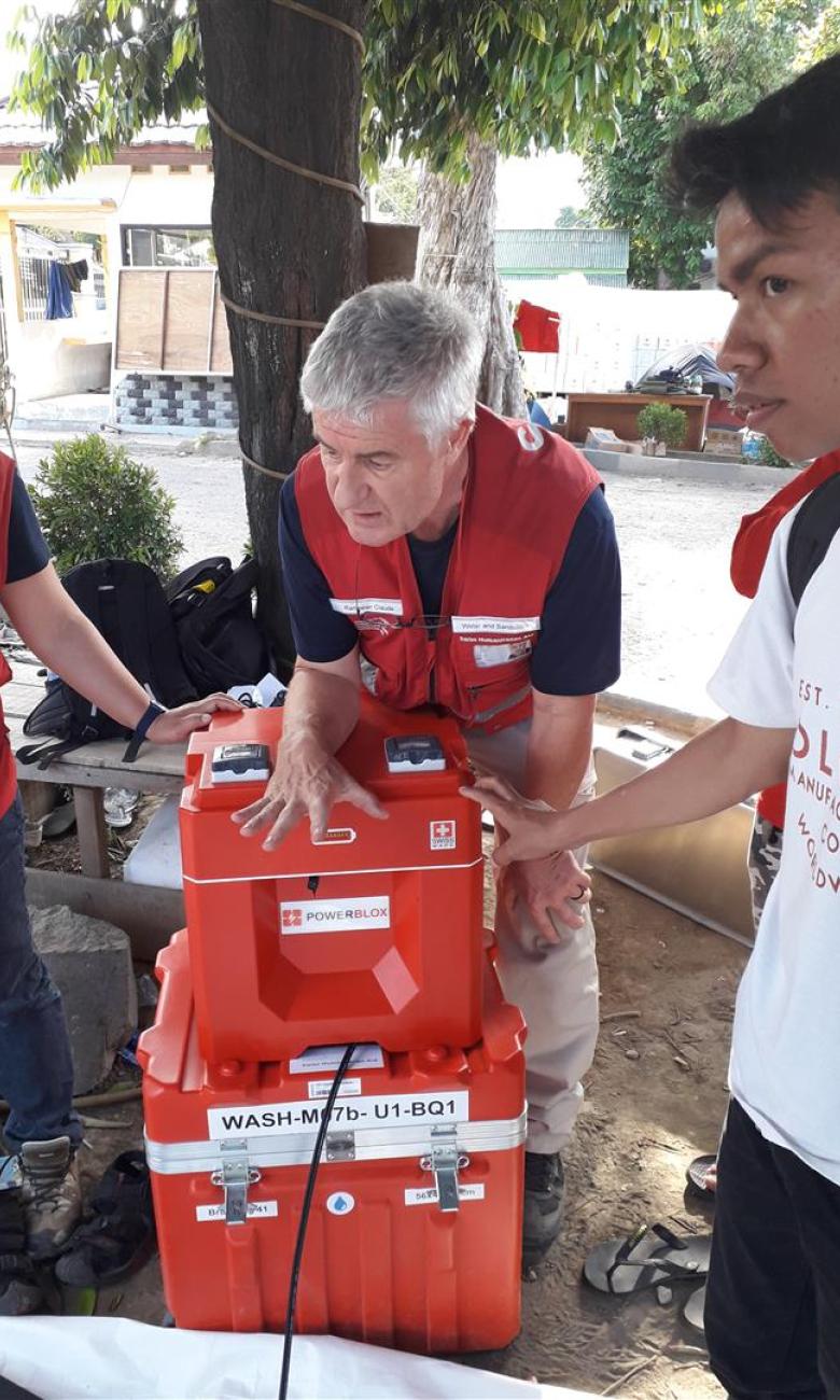 Experte des Schweizerischen Korps für Humanitäre Hilfe mit den tragbaren Stromboxen in Indonesien